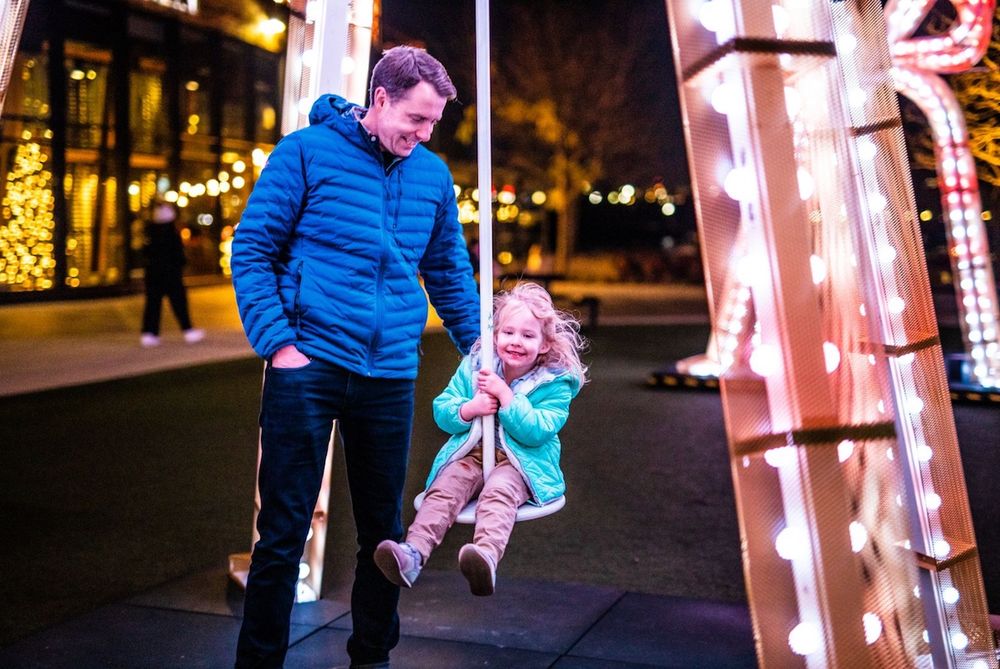 A little girl and her dad enjoy the glowing bells at Yards Park. Photo courtesy of Yards Park.