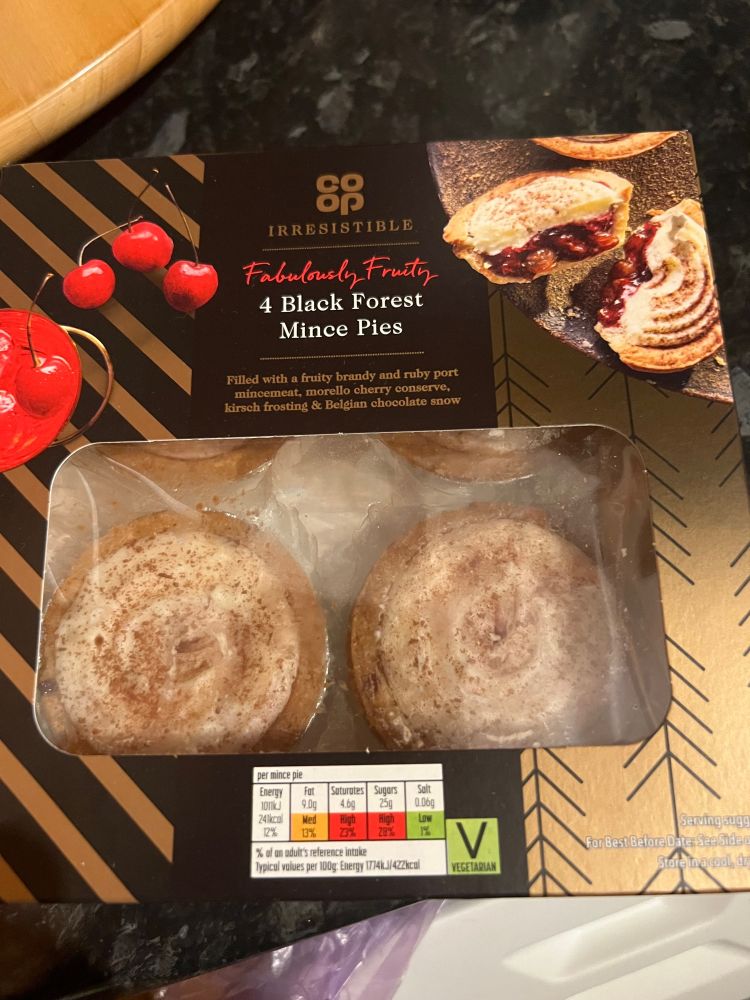 Black Forest Mince Pies shown in box with white frosted icing and cherry covered packaging.
