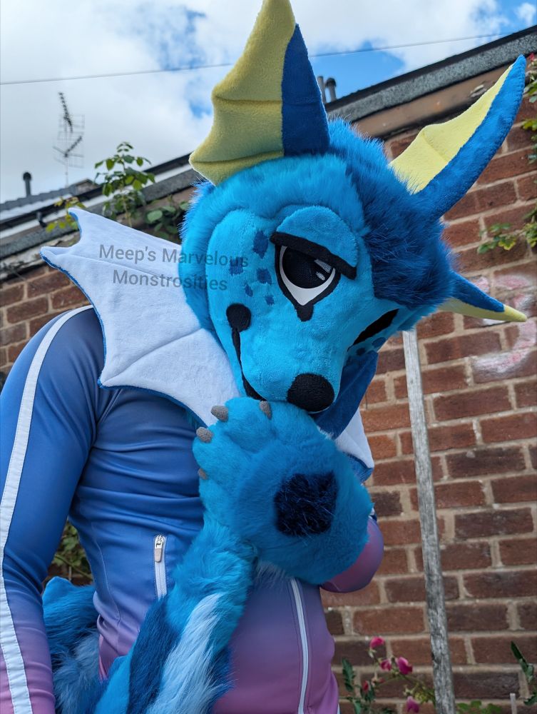 Vaporeon fursuit cuddling tail with expression eyelids on