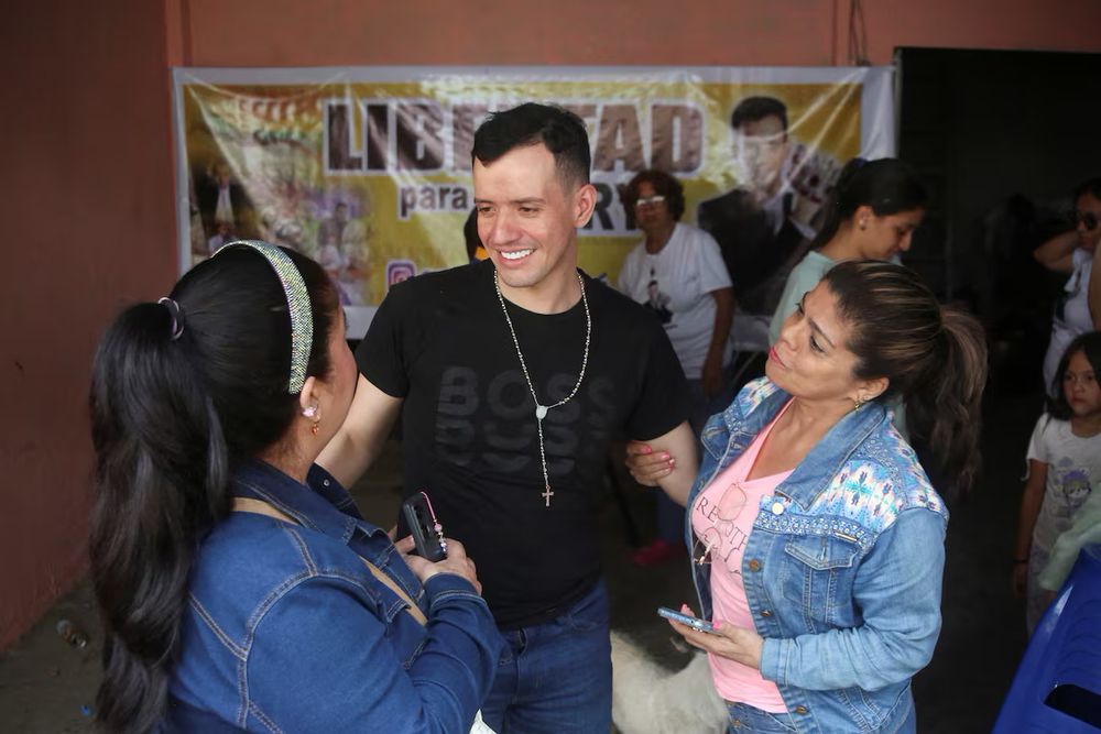 Andry with his friends, freed, smiling. A sign in the back says “Liberdad para Andry.”