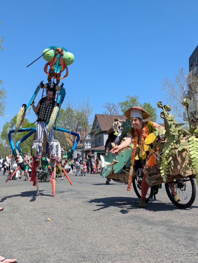 A nurse log bike and praying mantis make their way down a street