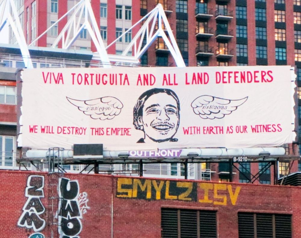 Billboard reads: viva tortuguita and all land defenders. We will destroy this empire. With earth as our witness.