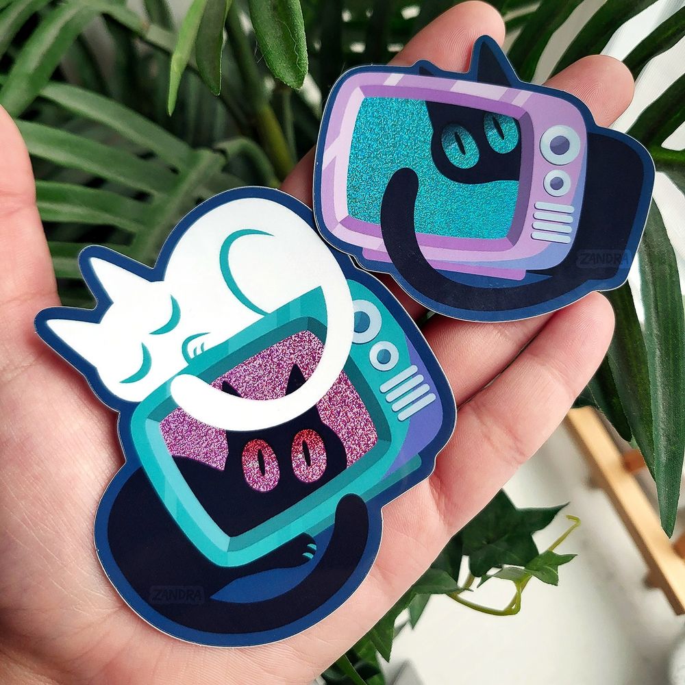 a photo of a sticker design by Zandra Illustration featuring two of the aforementioned television cat sticker designs from the previous images in the post. This image is meant to show the size comparison between the stickers.
