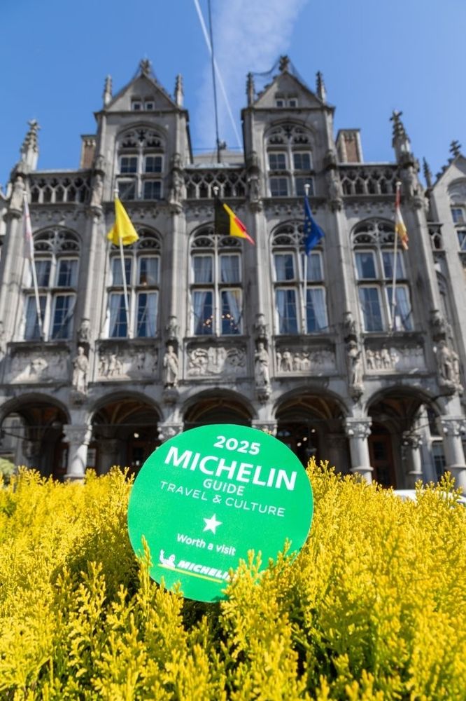 Photo de la façade du Palais des Princes-Évêques de Liège. La vignette "1 étoile" du Guide Michelin 2025 est posée sur la végétation 