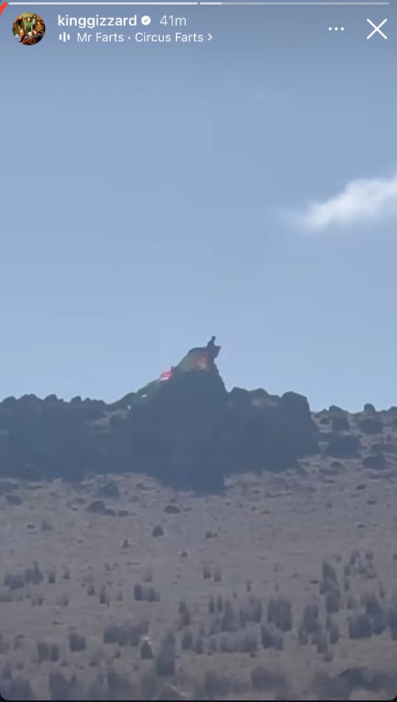 Image shows a man with a parachute on the side of a cliff. Taken from Gizzard’s Instagram story.