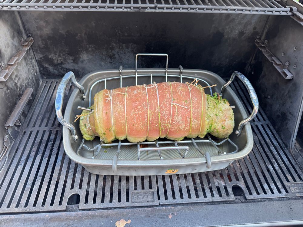 Pochetta in a dish inside a grill. The filling is a green paste, so it looks like a caterpillar. 