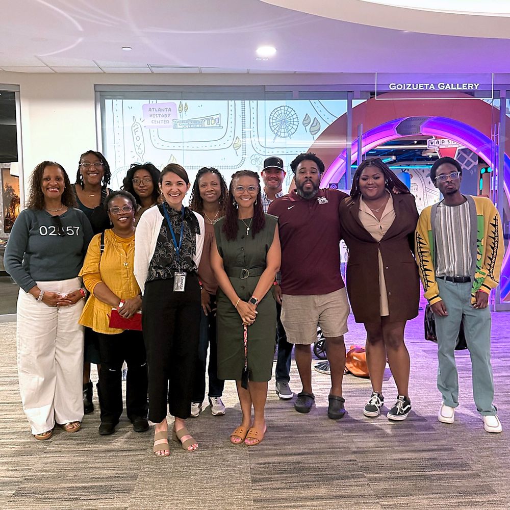 Staff from a civil and human rights museum stand together inside the Atlanta History Center’s Goizueta Gallery during a visit to explore the new children’s exhibit, smiling in front of a colorful interactive entrance.