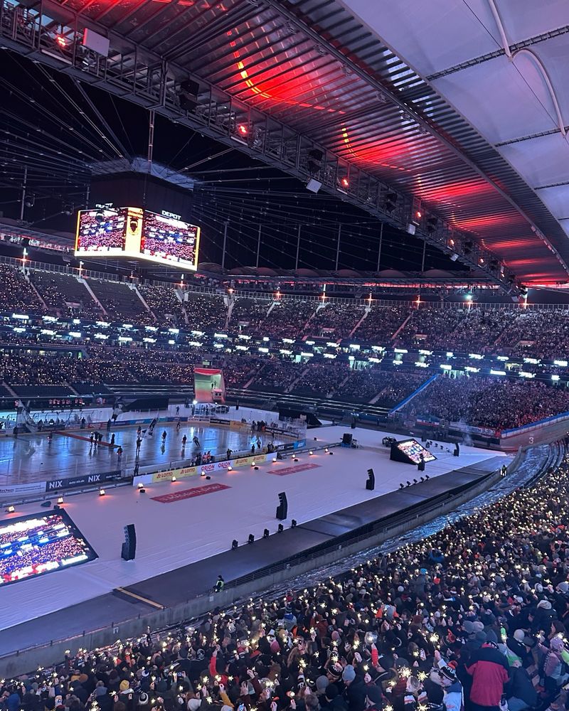 Waldstadion in Frankfurt mit einer Eisfläche in der Mitte. Die 45.110 Fans halten Wunderkerzen hoch. 