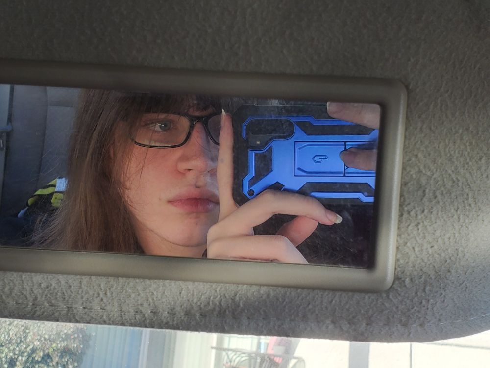 A picture taken of me in my partner's car mirror, my fingernails are so Long!!