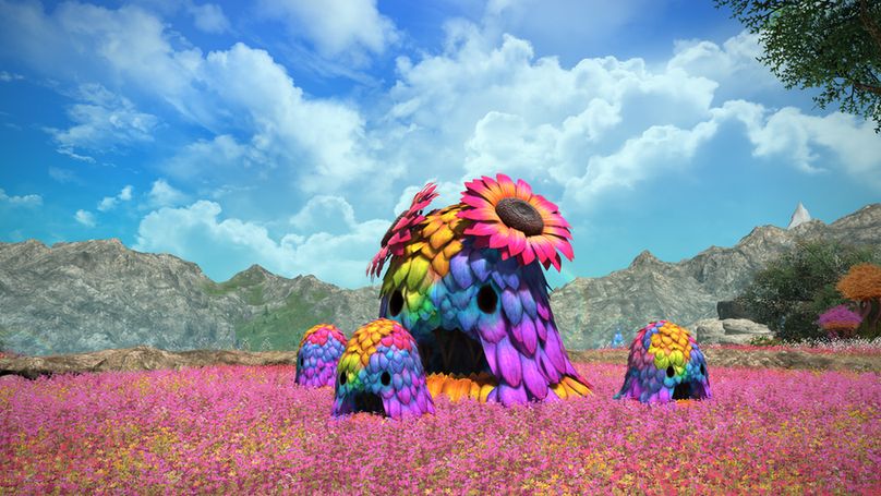 Ein Final Fantasy 14-Screenshot aus der Entwicklungsphase, auf dem eine Gruppe regenbogenbunter Grasgrummel auf einer pinken Wiese zu sehen sind. Der große Grasgrummel in der Mitte trägt zwei bunte Sonnenblumen auf dem Kopf.