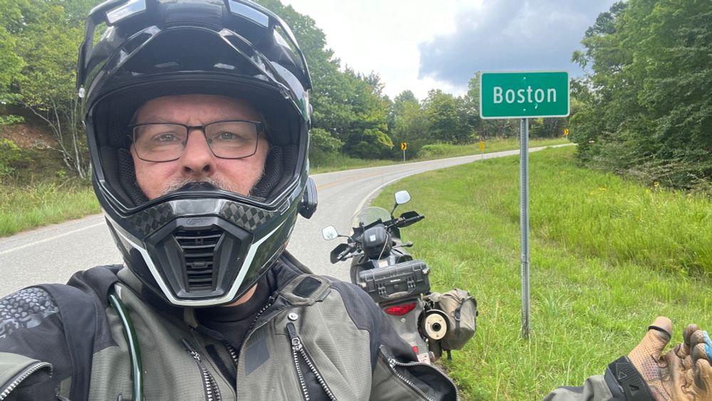 Me and my motorcycle standing next to a sign for the town of Boston, Arkansas.