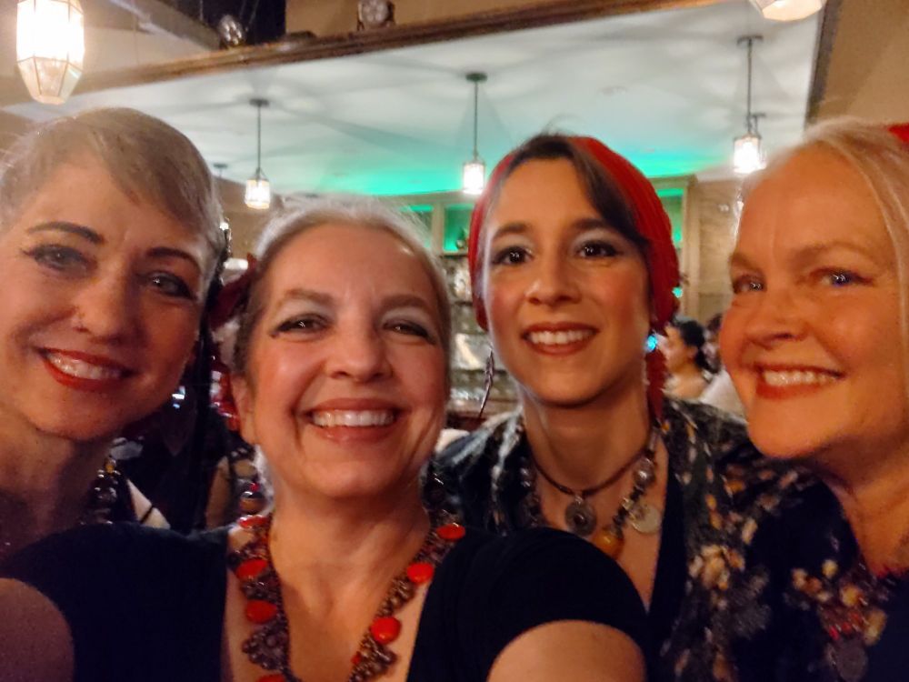 Big smiles selfie post dance. All 4 in costumes of red and black, the colors of our troupe.