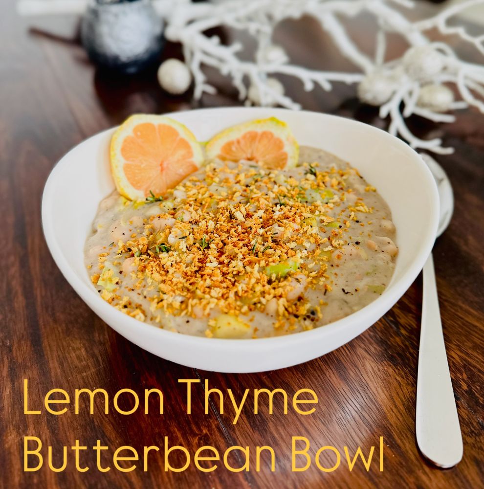 Creamy white bean and leek stew in a white bowl, topped with golden toasted breadcrumbs and fresh thyme, garnished with two lemon slices. The bowl sits on a dark wood table with minimal festive decor in the background.

Ingredients
	•	400 grams of butterbeans (with liquid if using canned)
	•	3 cloves of garlic, thinly sliced
	•	1 teaspoon of za’atar spice
	•	3 sprigs of thyme
	•	Zest of one lemon
	•	Juice of half a lemon
	•	100 grams of silken tofu
	•	3 medium-sized leeks, washed and finely sliced
	•	Yeast extract for seasoning
	•	Salt to taste
	•	1 tablespoon of olive oil

Instructions
	1.	Prep the Vegetables: Wash and finely slice the leeks. Peel the garlic and slice it thinly.
	2.	Sauté the Leeks: Heat a large pan over medium-high heat, add about a tablespoon of olive oil, and sauté the leeks for about 6 to 7 minutes. Then add the sliced garlic and cook for another 3 to 4 minutes.
	3.	Add the Beans and Seasonings: Pour in the butterbeans (with their liquid if using canned), season with a generous pinch of salt, add the za’atar, and stir in the lemon zest. Let everything come to a slight simmer.
	4.	Prepare the Creamy Sauce: In a separate container, combine the silken tofu, the lemon juice, and a pinch of salt. Once the leek and bean mixture is simmering, take about 3 to 4 tablespoons of it and add it to the container with the tofu mixture.
	5.	Blend and Combine: Use an immersion blender to blend the tofu mixture until smooth and creamy. Then pour this creamy sauce back into the pan, mix thoroughly, and adjust the seasoning to taste.