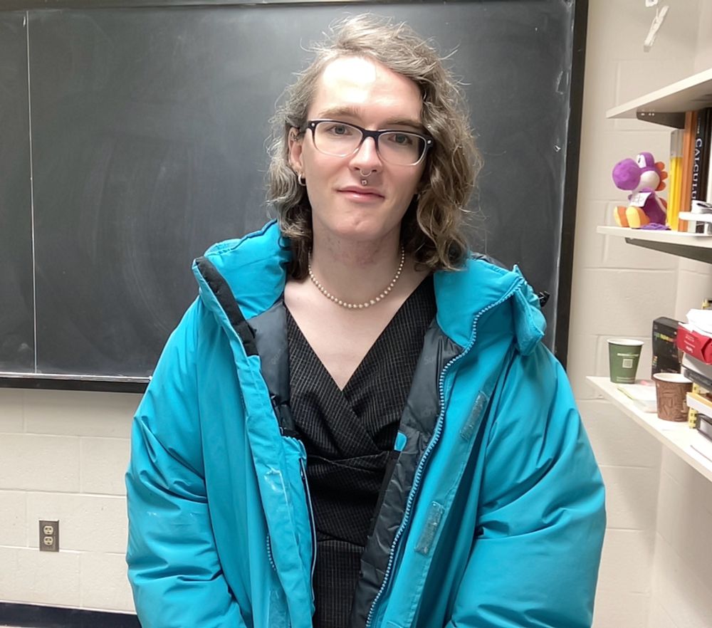 me in a nice outfit (dress, jewelry etc) except in a massive blue coat and in front of my office chalk board 