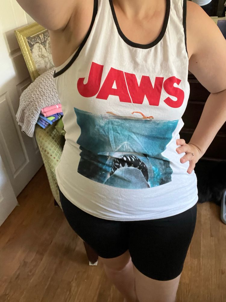 Wearing a tank top with the Jaws movie poster on it.