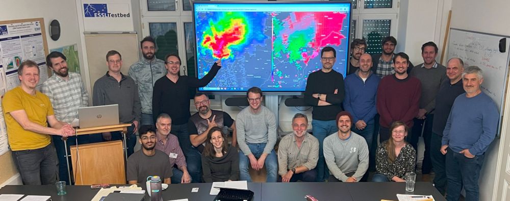 Participants of the workshop posing in front of radar imagery displayed on a screen