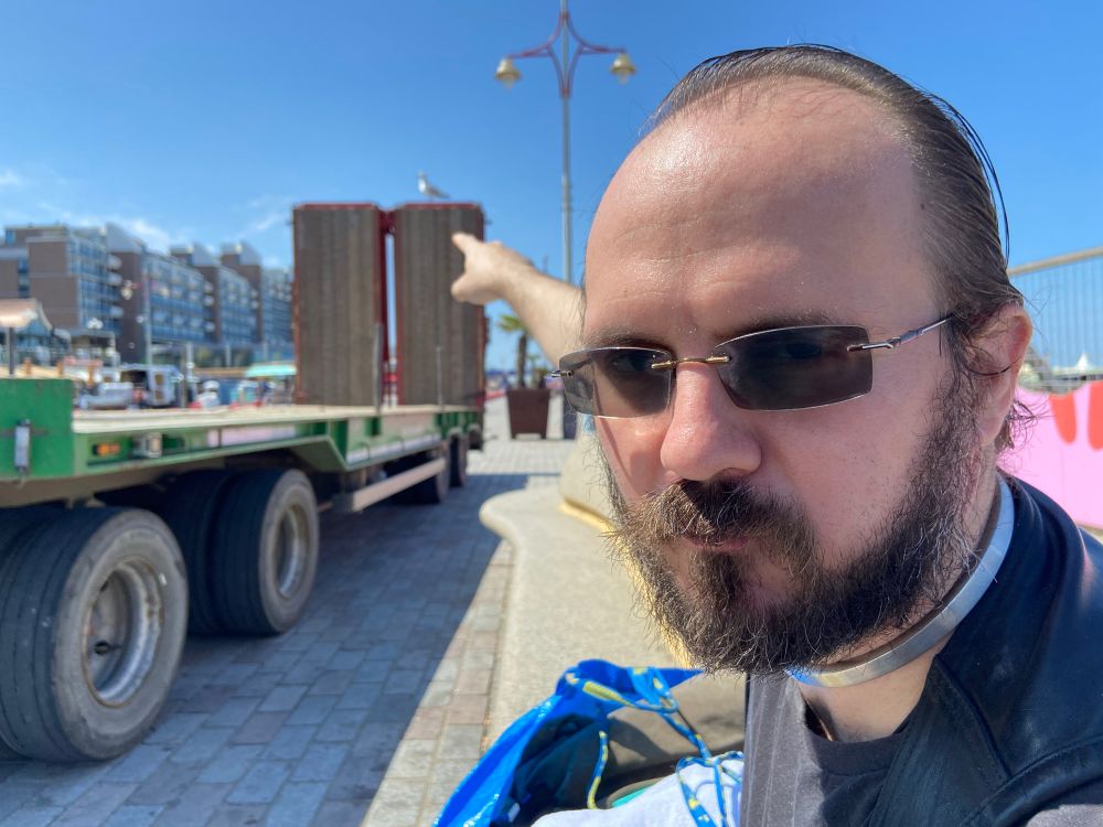 Picture of me pointing at a seagull perched on top of a nearby flatbed truck, who clearly wanted to eat my food. 