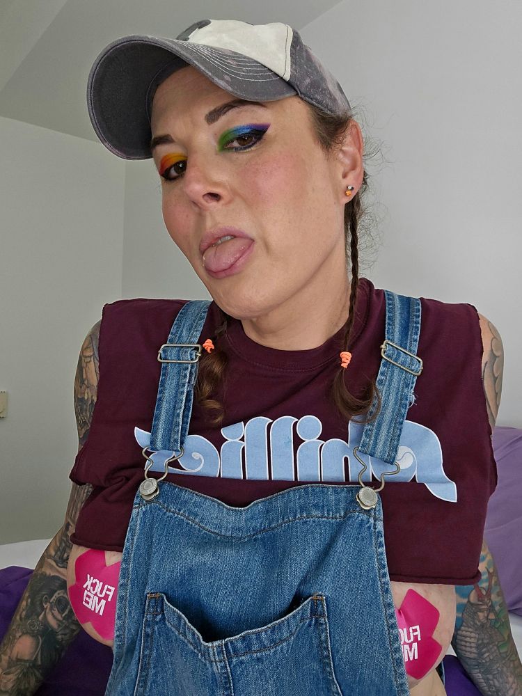 Jade rocking her barely there maroon Philadelphia Phillies cropped tshirt under her jean short overalls. Her nipple pasties are hot pink and read "fuck me" on them. Her eye shadow is rainbow with one eye that's purple, blue & green. The other eye is red, orange & yellow. 