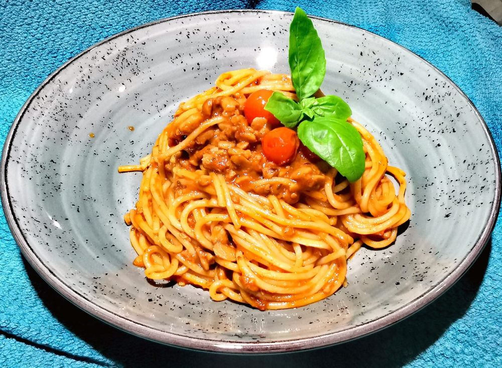 Spaghetti mit Tempeh-Tomatensauce und frischem Basilikum.