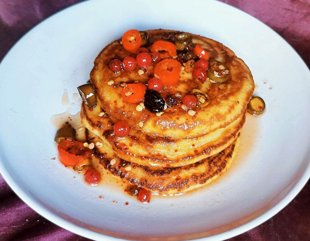 3 dicke Pfannkuchen mit Topping auf weißem Teller.