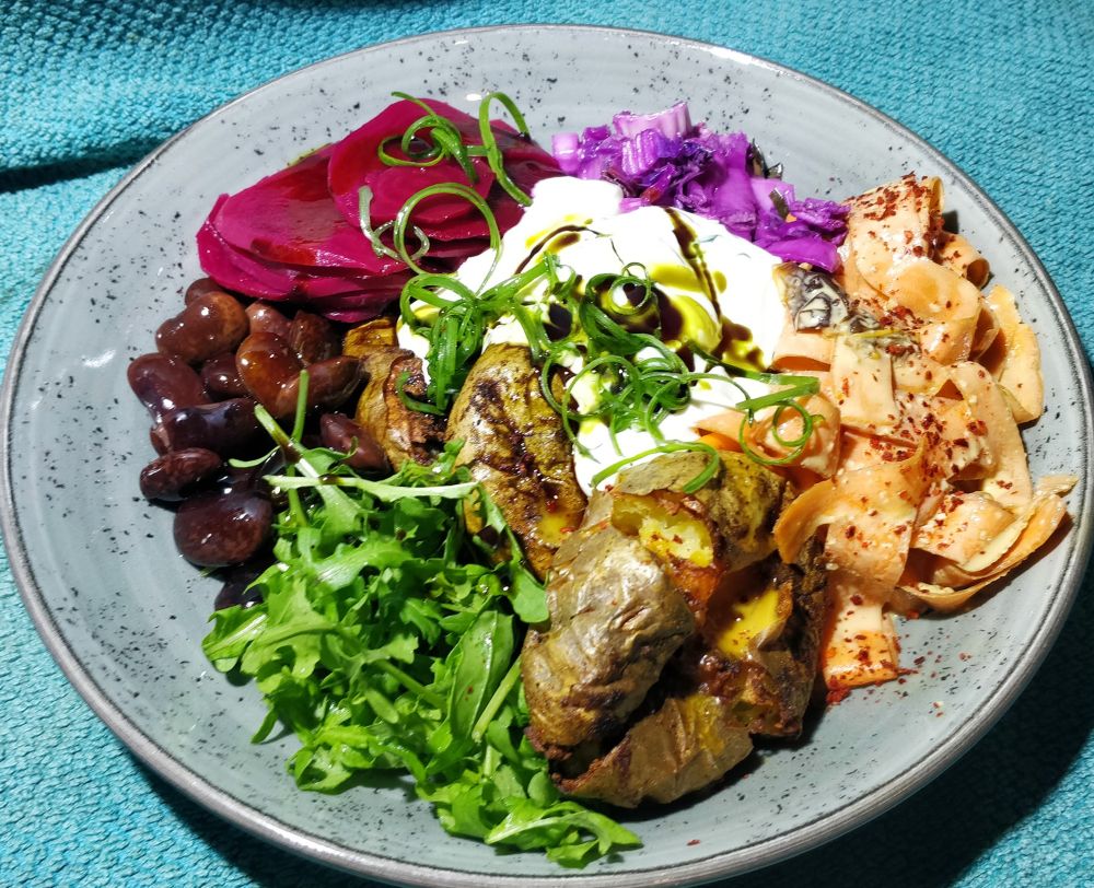 Beschriebener Salat auf grauem Teller.