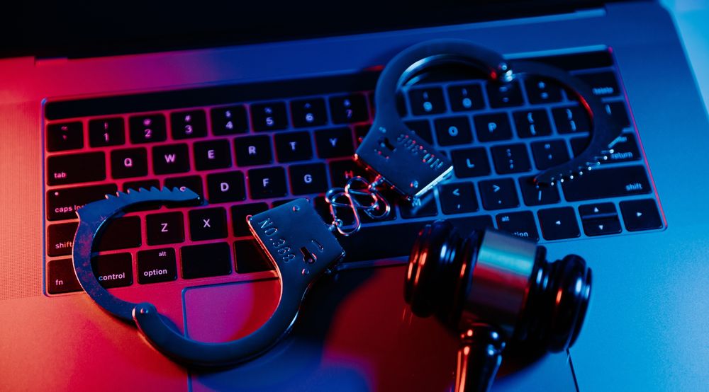 a pair of handcuffs and a gavel on a keyboard