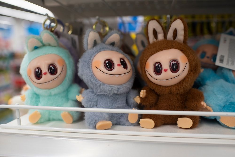 Fake Labubus on a shelf, some smiling human-like figures in animal outfits
