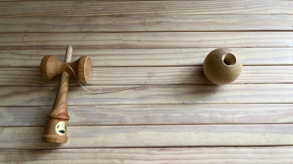 a picture of a wooden cup and ball toy, also known as a kendama 
