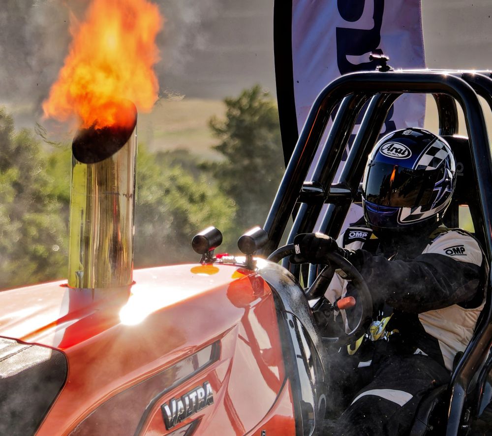 Photo of an orange tractor with flames coming out of the exhaust stack, the flames are reflected in the helmet of the driver.
Olympus E-M1MarkII
LEICA DG 100-400/F4.0-6.3
@ƒ/4.5 113.0mm 1/800s ISO250