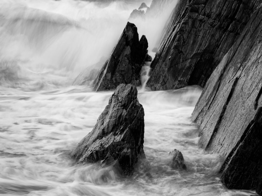 Black and white picture of slabs of rock in the sea using a slow shutter speed to show the effect of the water swirling around them.
OM Digital Solutions OM-1
OLYMPUS M.12-100mm F4.0
@ƒ/8.0 92.0 mm 0.5s ISO200


