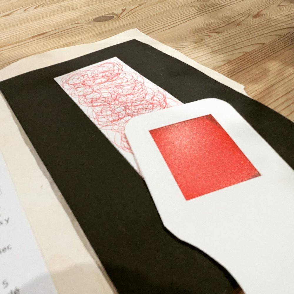 Gros plan sur le secret, un texte caché sous des marques rouges, et la loupe, papier transparent rouge, pour le lire.