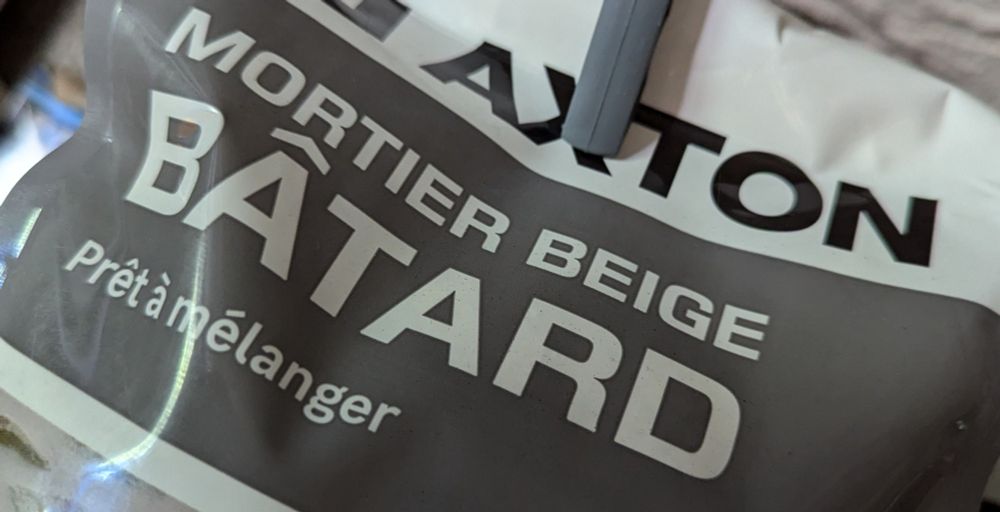 Paquet de mortier où il est indiqué : "mortier beige bâtard prêt à mélanger"