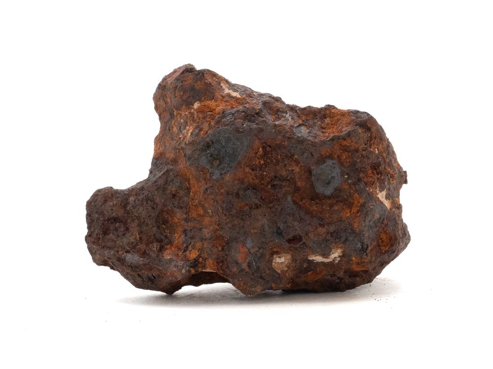 Photo of a fragment of the Canyon Diablo meteorite, an iron-nickel meteorite with a dark, weathered surface and rough irregular edges. This is the type of fragment used by Dr Clair Patterson to measure lead isotopes and determine the age of the Earth at approximately 4.55 billions years
