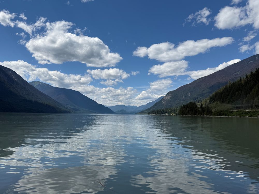 Picturesque scene of Lillooet Lake in BC Canada. Summer day with blue sky's and fluffy cumulus clouds. 