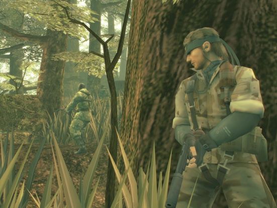 Screenshot from the video game Metal Gear Solid 3. Depicts the protagonist Naked Snake dressed in an olive camouflaged uniform and a black bandana, holding a pistol and pointing it toward the ground. He is peeking out from behind a tree, watching a green uniformed officer patrol through the nearby jungle.