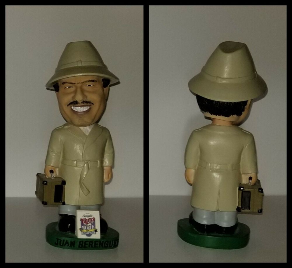 Pictured is a bobblehead of former Twins pitcher Juan Berenguer. The figure is dressed in a trenchcoat and carries a briefcase.