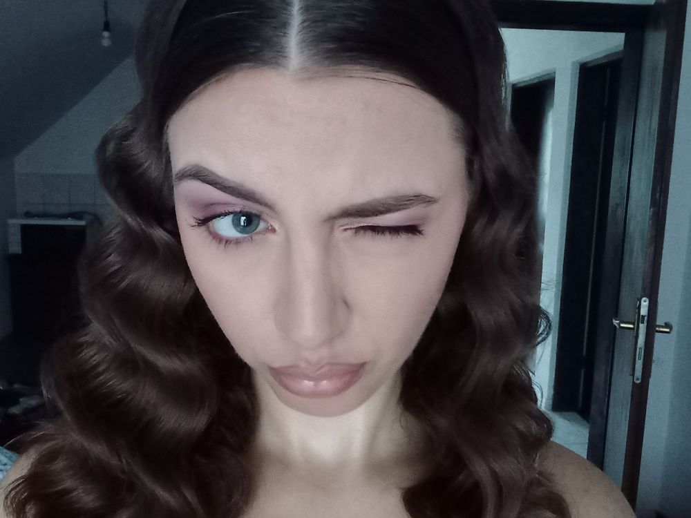 selfie where i'm winking, I have a full face of makeup and my hair is styled in waves