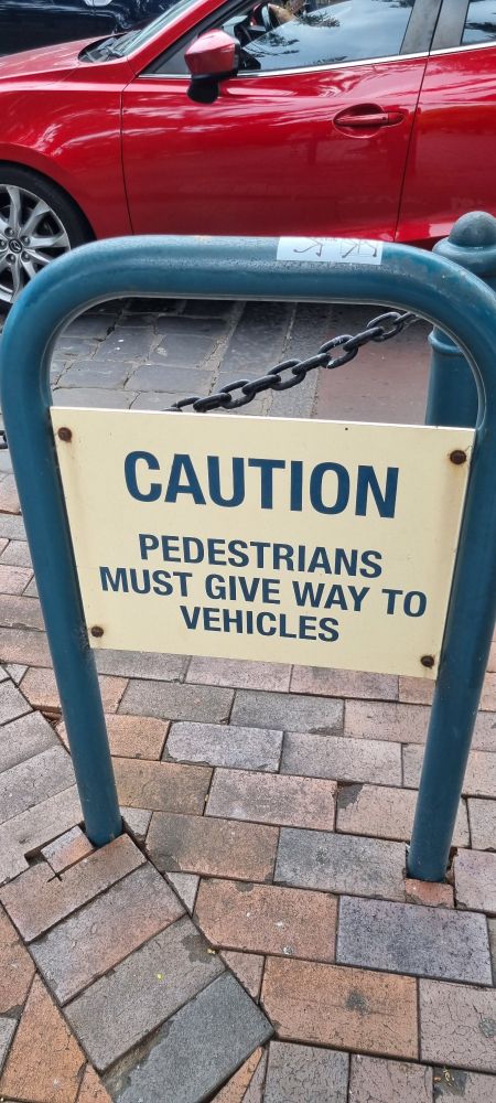 A sign saying "caution pedestrians must give way to vehicles" in the Kiama town centre. The crossing looks like a pedestrian crossing. I just stepped out in front of cars and made them stop. Kiama town centre would be nice without the car brained design 