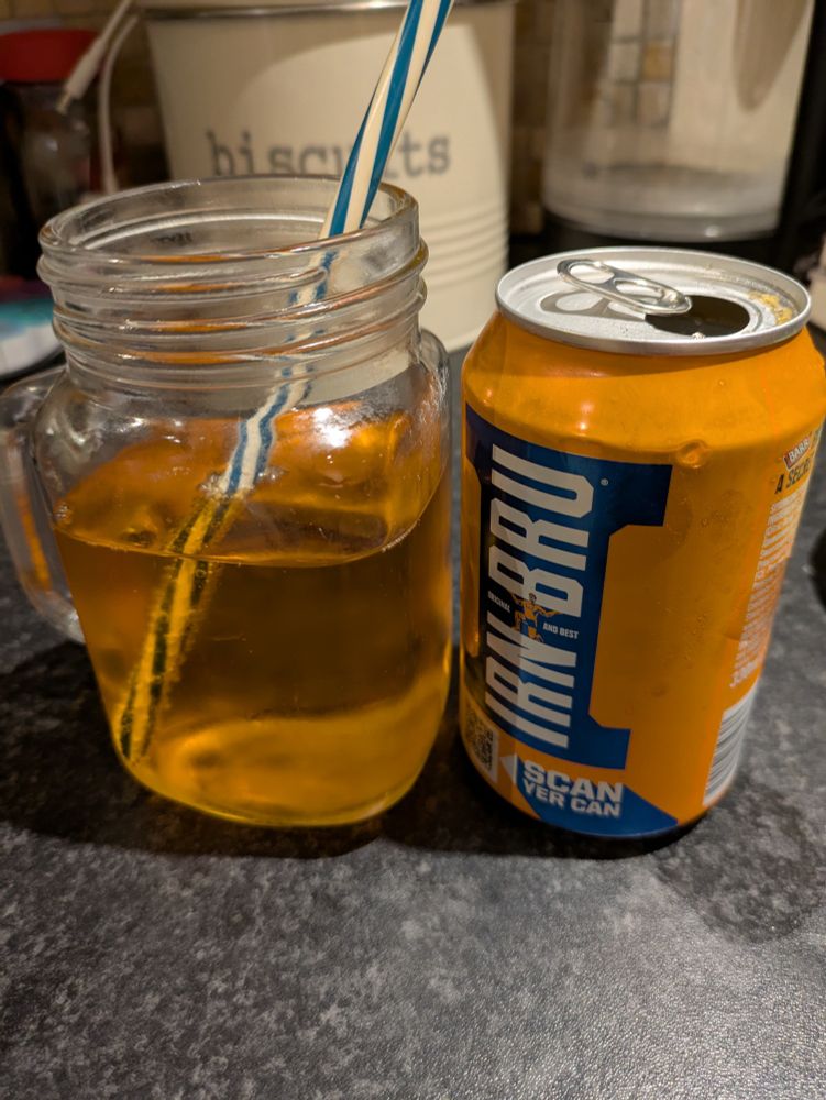 Photo of an empty Irn Bru can standing next to a glass with the drink poured inside. It's bright orange and has a blue straw.

Unsure what version of the recipie it is, but most likely the new one as it tastes different. 