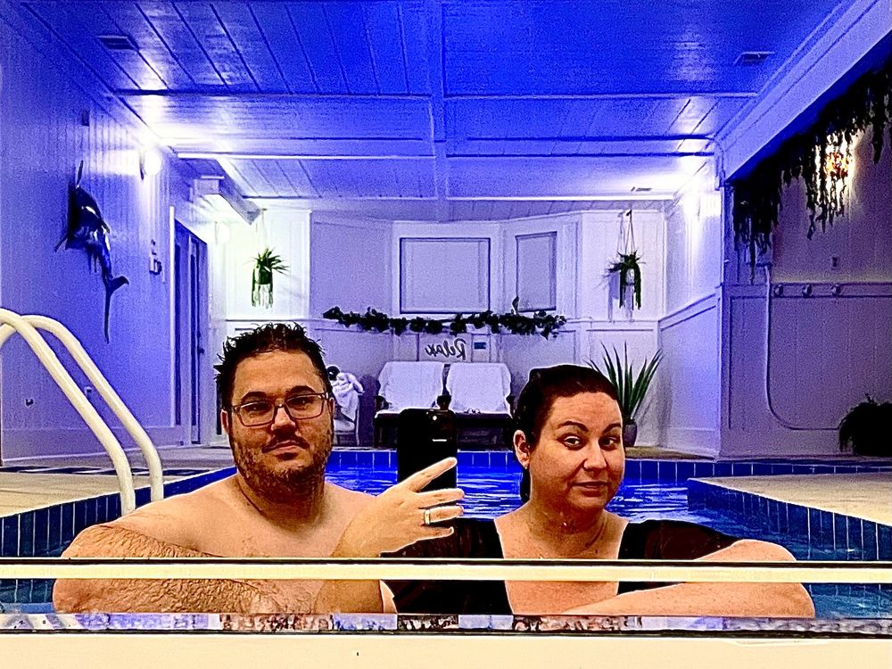 Two nerds trying to look cool and nonchalant in a pool, facing a mirror.