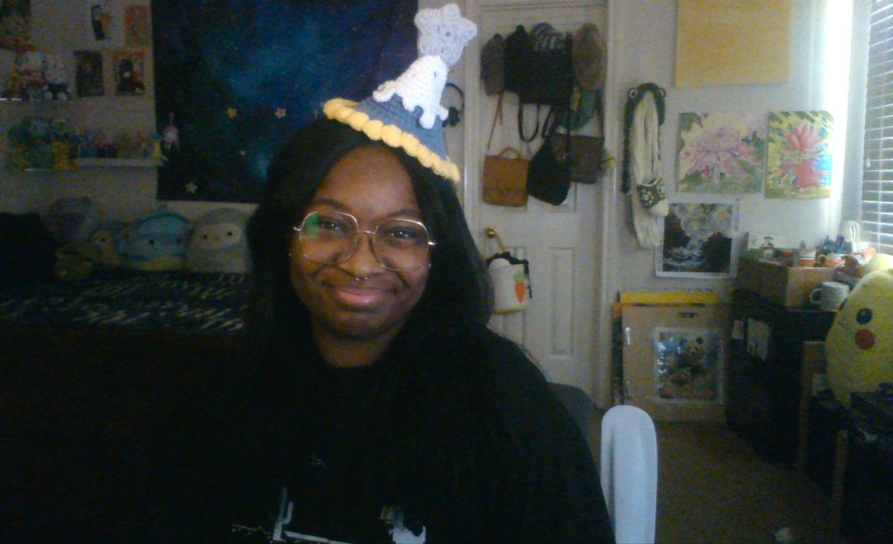 a photo of Starcelynn smiling while wearing a crochet party hat.