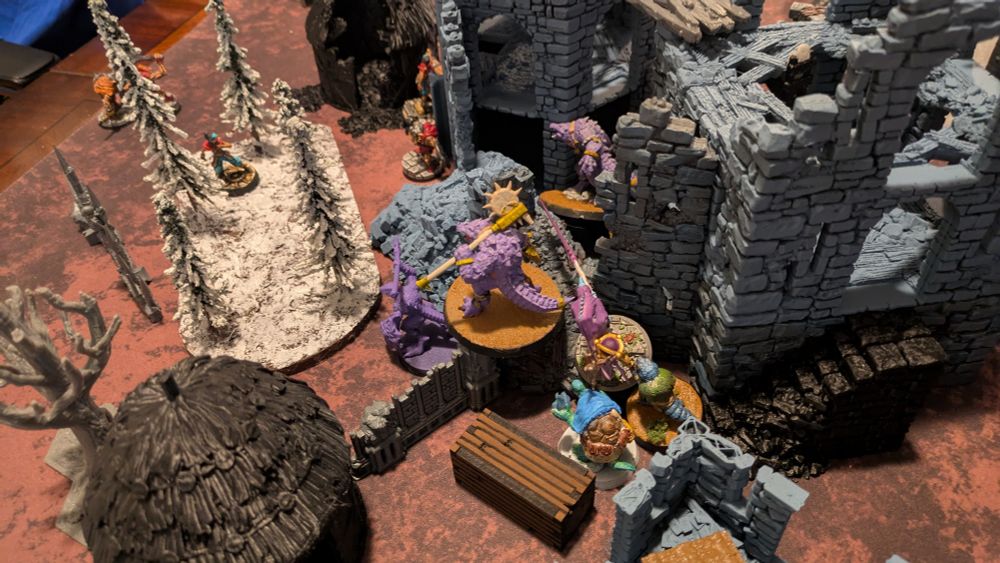 The lizard men warband knock down a wall and quickly rush inside to secure the treasure inside the keep 