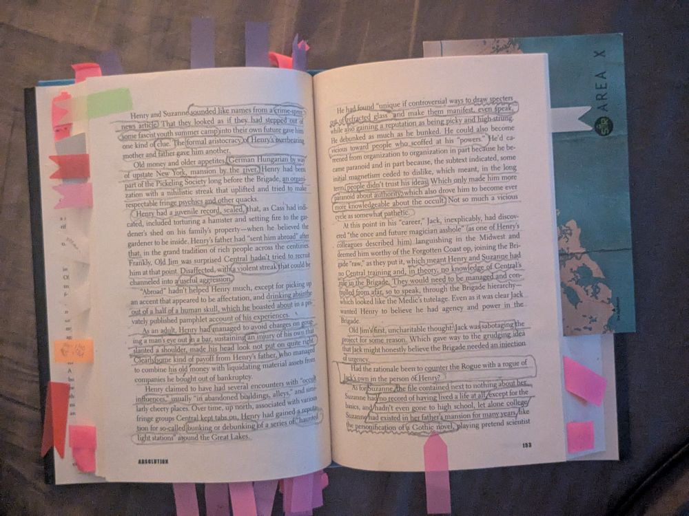 A novel lying open with a nearly uncountable number or sticky note markers of various colors in every possible direction. The text on the page has been annotated to an equally absurd extent, with extensive underlining and circling to make certain ideas stand out on the page.