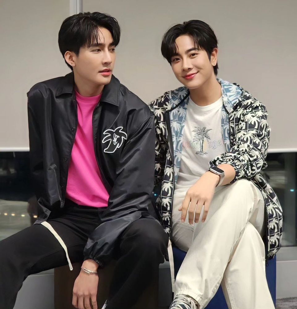 Earth and Mix sitting next to each other during their LasLOOK Live, Earth looking at Mix and Mix looking at the camera.