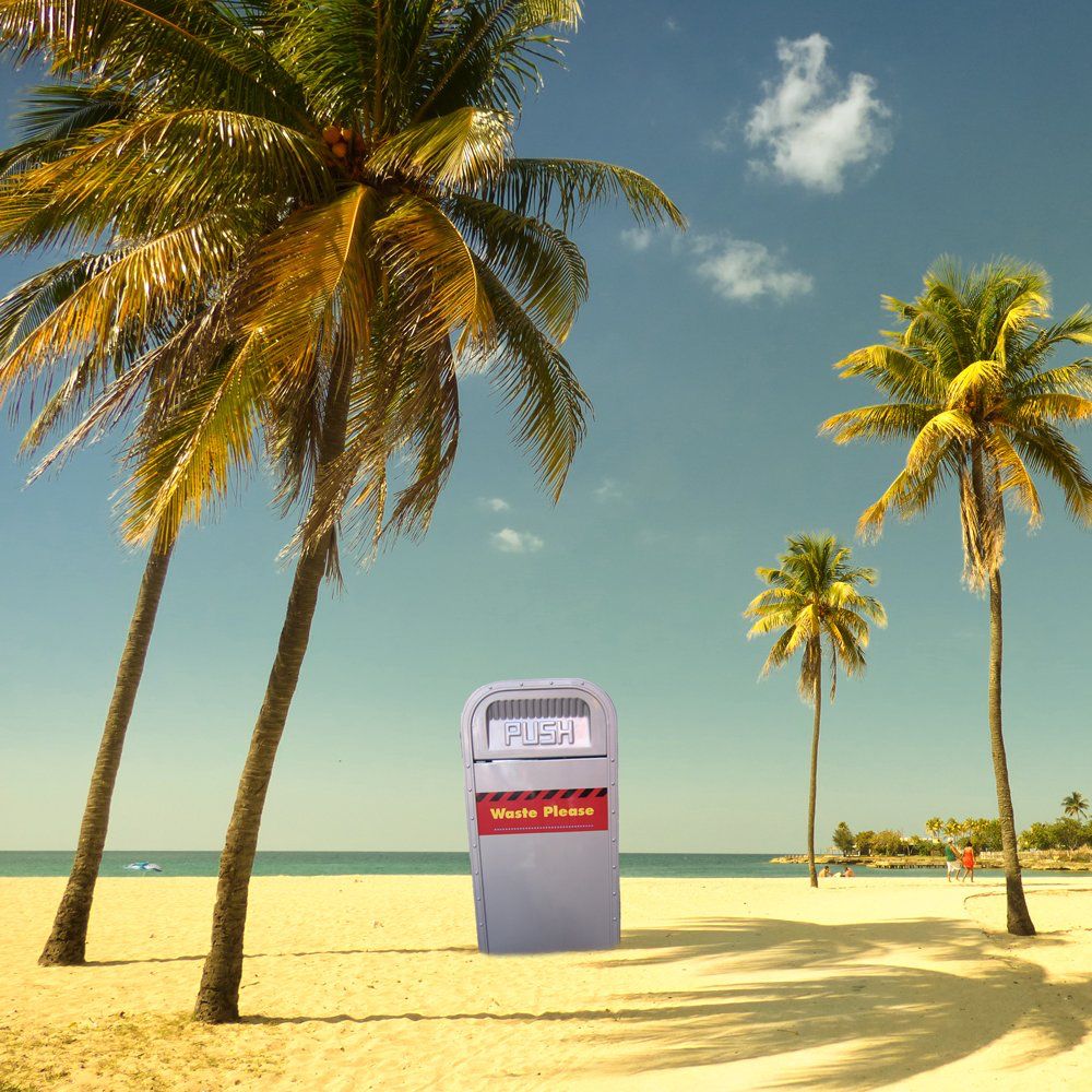 A colorful trash bin labeled "Waste Please" stands on a sunny beach surrounded by palm trees, with a clear blue sky and ocean in the background.