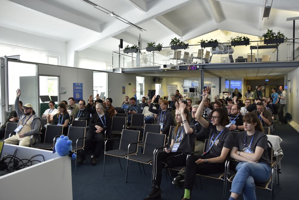 People during session planning, rasing hands to show that they would like to attend a session