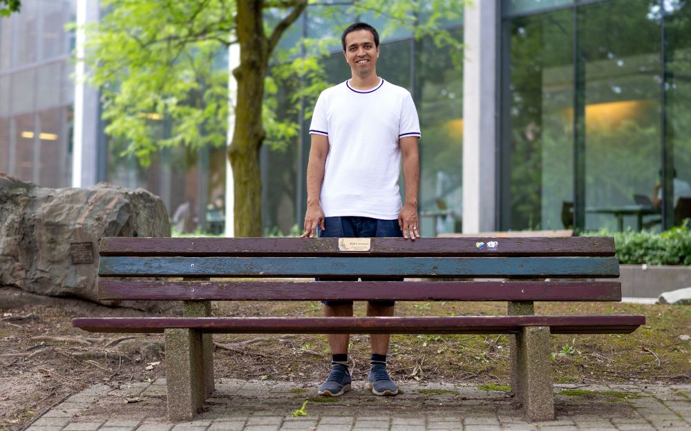 Professor Sepehr Assadi stands by a bench in Waterloo's Peter Russell Rock Garden.