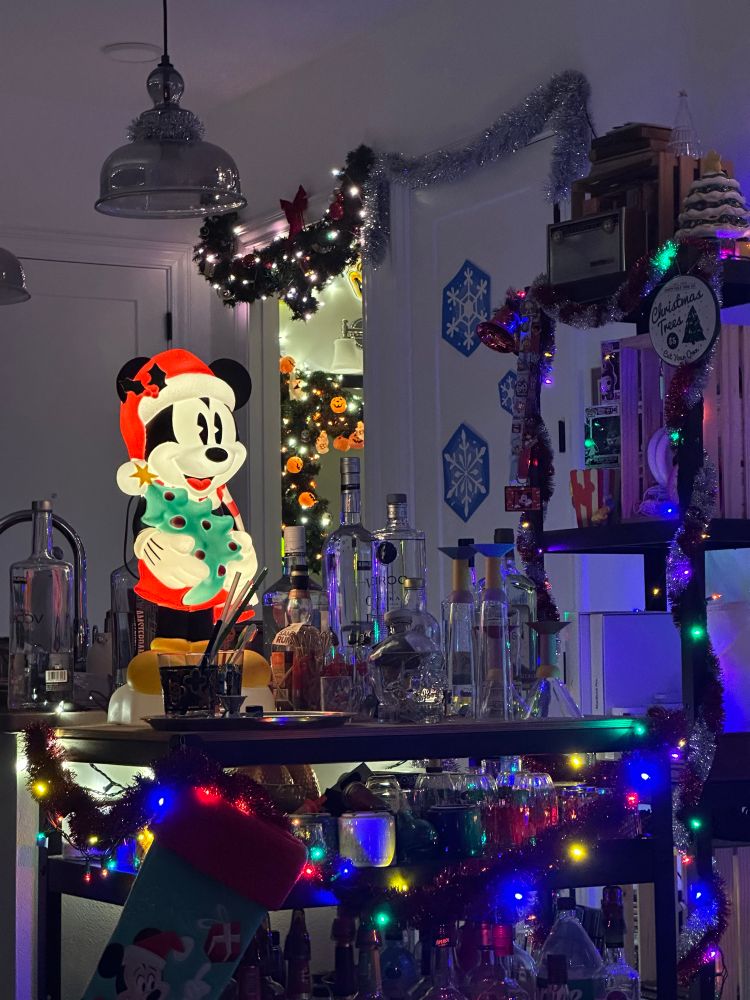 Mickey Mouse with a Santa hat on blow mold sitting on a bar cart 
 