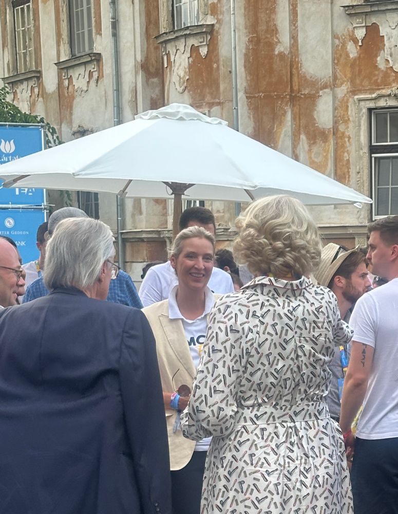 Ludwig und Weidel (im MCC T-shirt) nach dem Panel, lächelnd im Gespräch 
