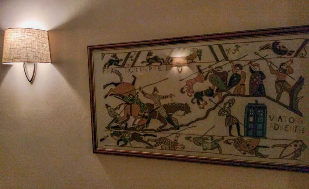 The same tapestry on a cream wall near a side light.